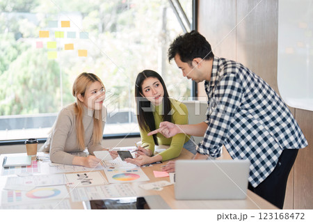 Diverse team discussing design concepts and collaborating in a modern office. Diverse team discussing design concepts and collaborating in a modern office. 123168472