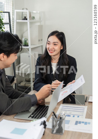 Diverse business colleagues discussing charts and data analysis in a contemporary office setting. 123168599