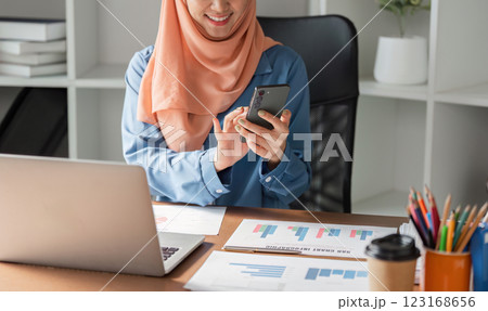 Muslim woman in hijab using smartphone while...の写真素材 [123168656] - PIXTA
