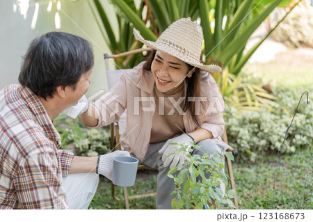 Elderly Asian couple sharing a joyful moment while gardening together. 123168673