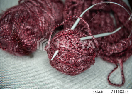 yarns, knitting needles and pattern sample on grey background. 123168838