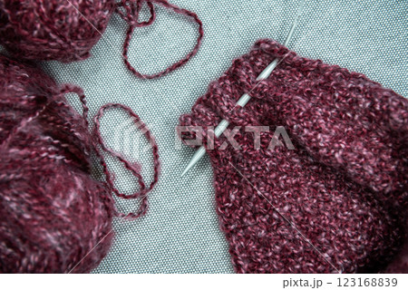yarns, knitting needles and pattern sample on grey background. 123168839