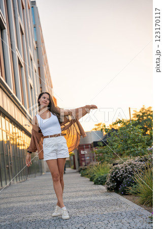 Attractive young woman enjoying her free time at sunset outdoor. Happy girl portrait at summer. Freedom lifestyle summer concept. Sun glow on background. 123170117