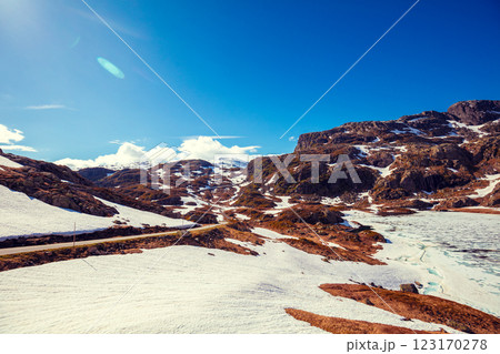 The mountain range is covered with melting snow. Nature park on road 520 from Roldal to Sauda in summer. Beautiful nature of Norway The mountain range is covered with melting snow. Nature park on road 520 from Roldal to Sauda in summer. Beautiful nature of Norway 123170278