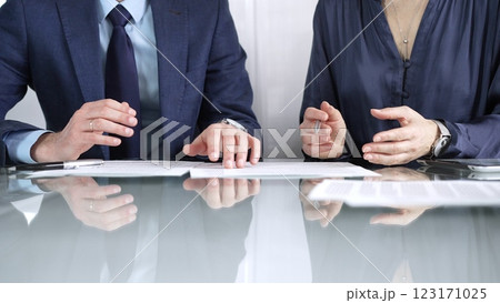 Business partners or lawyers are discussing contract papers during a meeting, negotiating and making decisions together. Business people concept, close up Business partners or lawyers are discussing contract papers during a meeting, negotiating and making decisions together. Business people concept, close up 123171025