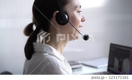 Adult female call center operator in assisting clients online, providing customer support and answering inquiries. Business call center concept 123171161
