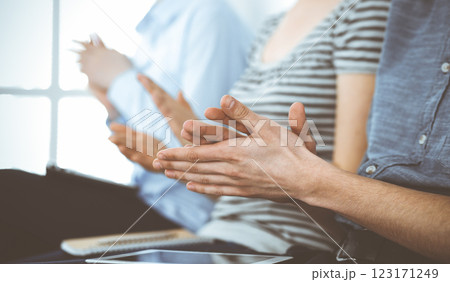 Business people clapping at meeting or conference, close-up of hands. Group of unknown businessmen and women in modern white office. Success teamwork, corporate coaching and applause concept 123171249