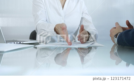 Business partners or lawyers are analyzing documents and collaborating on a project during a productive office meeting while sitting at the glass table. Businesspeople concept 123171472