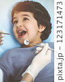 Cute arab boy sitting at dental chair with open mouth during oral checking up with doctor. Visiting sunny dentist office 123171473
