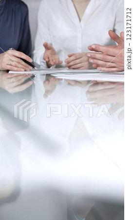Business people are reviewing contract terms during a meeting, negotiating and making decisions together, vertical close up view. Copy space area Business people are reviewing contract terms during a meeting, negotiating and making decisions together, vertical close up view. Copy space area 123171712