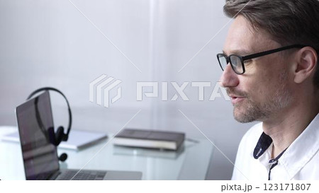 Businessman office worker attending online meeting using laptop and microphone, working remotely from home or office. Businesspeople concept Businessman office worker attending online meeting using laptop and microphone, working remotely from home or office. Businesspeople concept 123171807