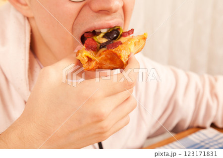 Bearded Caucasian white mature male in pink t-shirt eating delicious pizza slices Bearded Caucasian white mature male in pink t-shirt eating delicious pizza slices 123171831