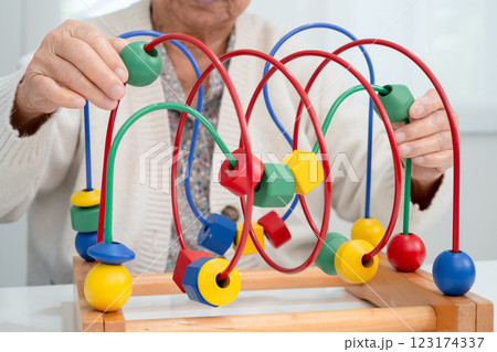 Asian elderly woman playing enhancing skill board game. Asian elderly woman playing enhancing skill board game. 123174337