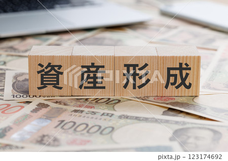 お金の上に資産形成と書かれたブロック 123174692