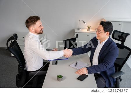 Professional Business Meeting in Modern Office With Two Confident Businessmen Shaking Hands 123174877