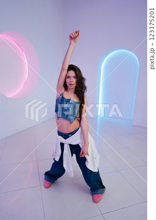 Young woman striking a confident pose in a stylish setting during daylight 123175201