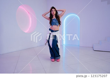 Young woman posing in modern indoor space with colorful lighting effects Young woman posing in modern indoor space with colorful lighting effects 123175207