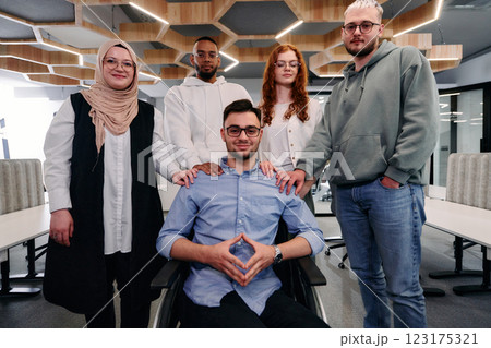 Young businessmen in a modern office extend a handshake to their business colleague in a wheelchair, showcasing inclusivity, support, and unity in the corporate environment. 123175321