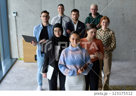 A diverse and determined team of business professionals stands confidently in an office, ready to tackle new business plans and challenges with a focus on success and growth 123175512