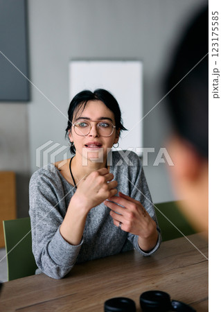 A close up portrait of a young businesswoman engaged in a professional meeting, confidently discussing ideas and strategies with her colleagues 123175585