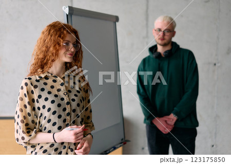 A business colleague collaboratively presenting business goals and strategies to their team in a professional office setting A business colleague collaboratively presenting business goals and strategies to their team in a professional office setting 123175850