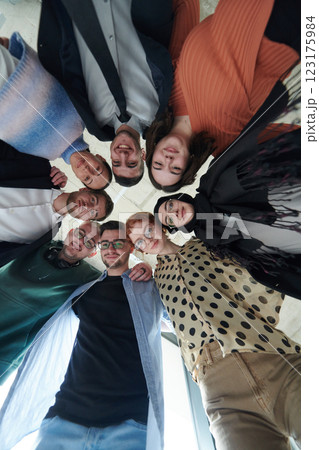 A diverse group of business professionals standing together in a powerful, united pose, captured from a low-angle perspective, exuding confidence and teamwork 123175984