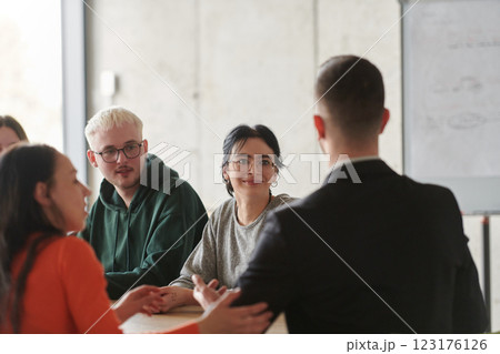 A diverse multiethnic business team engages in a collaborative meeting, discussing strategies and solutions in a modern office setting 123176126