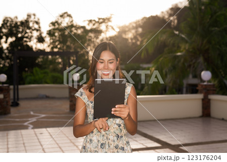 Young woman using tablet computer outdoors during summer Young woman using tablet computer outdoors during summer 123176204