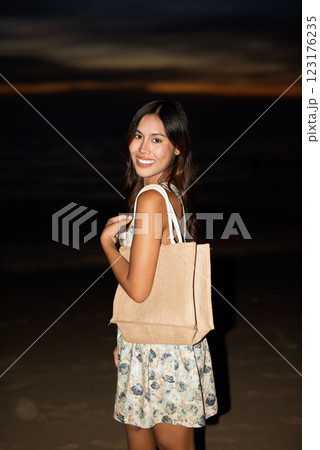 Portrait of young woman on the beach during night 123176235