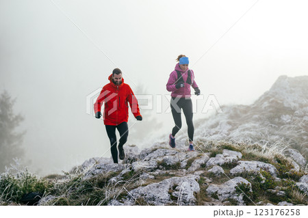 Trail running couple man and woman running on a mountain path 123176258