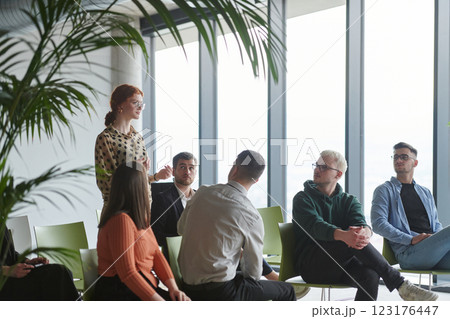 A diverse group of business professionals sits attentively in a modern office, actively participating in a training session led by an instructor, focusing on the latest technological advancements in 123176447