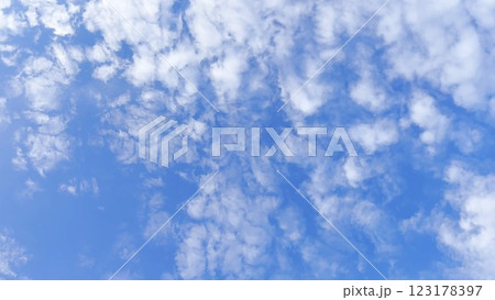 Camera move behind white fluffy clouds on blue sky at summer sunny day. Beautiful nature background. Close up Slow motion 123178397