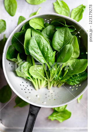 Heap of fresh green spinach leaves in a metal colander 123179278