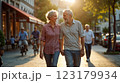 Happy European senior couple in love walking together in city streets on sunny summer evening 123179934