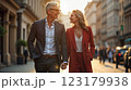 Happy European senior couple in love walking together in city streets on sunny summer evening 123179938