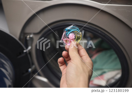 Using Laundry Detergent Pods While Doing Laundry in the Washing Machine with Clothes 123180199