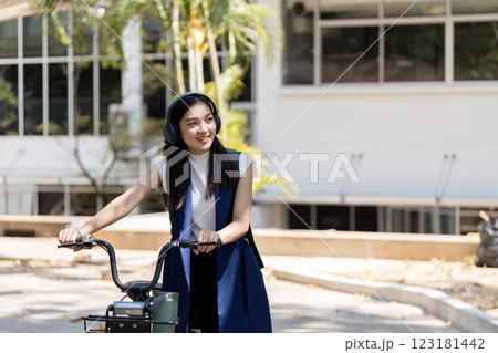 Friendly businesswoman smiling while riding her eco friendly bike in the city Friendly businesswoman smiling while riding her eco friendly bike in the city 123181442