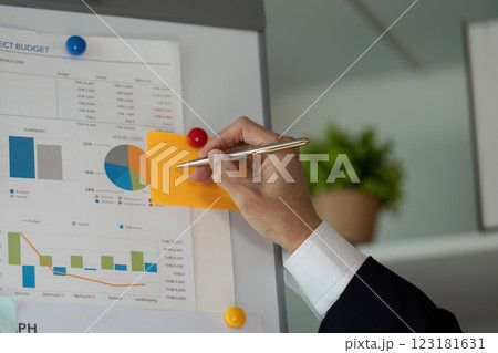 Elderly financial expert analyzing budget charts in a modern office, focusing on planning and tax strategies. 123181631