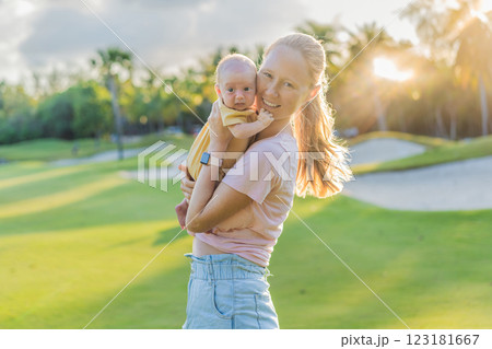 Young mother enjoying a peaceful walk in the park with her one-month-old baby. Motherhood, bonding, and outdoor family time concept Young mother enjoying a peaceful walk in the park with her one-month-old baby. Motherhood, bonding, and outdoor family time concept 123181667