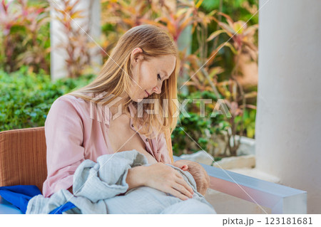 A mother breastfeeds her baby in a cozy cafe, embracing a natural and nurturing moment amidst a casual, public setting. This intimate scene reflects modern parenting, maternal love, and the beauty of 123181681