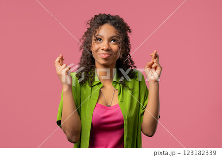 African teenager girl praying crossed fingers on Pink.Young adult begs someone African teenager girl praying crossed fingers on Pink.Young adult begs someone 123182339