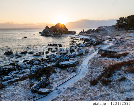 空撮「青森県」雪景色の中須賀が朝日でオレンジ色に包まれる風景・種差海岸　八戸市 123182553