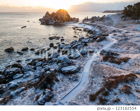 空撮「青森県」雪景色の中須賀が朝日でオレンジ色に包まれる風景・種差海岸　八戸市 123182554