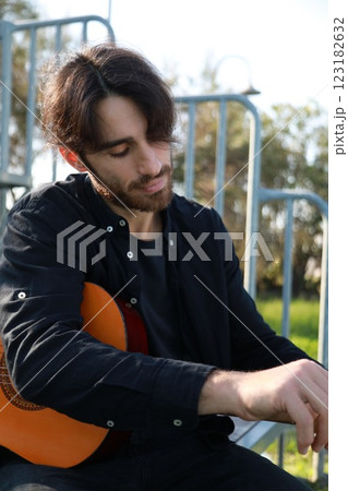 Man's Hand Passes Guitar Strings Preparatively Man's Hand Passes Guitar Strings Preparatively 123182632