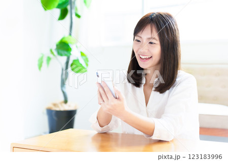 自宅でスマートフォンを使う女性 自宅でスマートフォンを使う女性 123183996