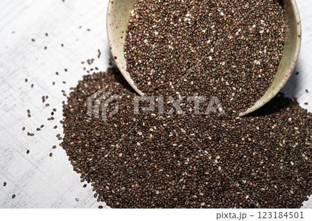 Chia seeds in bowl on wood board. 123184501