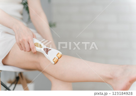 美容家電のローラーを使ってふくらはぎの老廃物を流すアジア人女性 美容家電のローラーを使ってふくらはぎの老廃物を流すアジア人女性 123184928