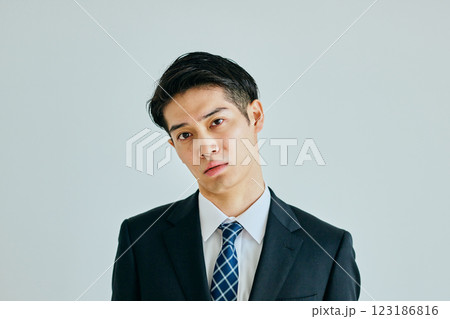 首をかしげる20代の若い男性 123186816
