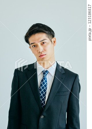 首をかしげる20代の若い男性 首をかしげる20代の若い男性 123186817