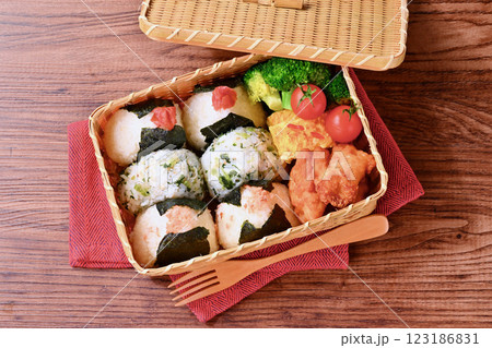 おにぎりのお弁当。しゃけ、野沢菜じゃこ、梅干し。唐揚げ、卵焼き、ブロッコリー、ミニトマト。 おにぎりのお弁当。しゃけ、野沢菜じゃこ、梅干し。唐揚げ、卵焼き、ブロッコリー、ミニトマト。 123186831